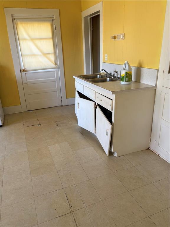 kitchen with light tile patterned floors, light countertops, and a sink