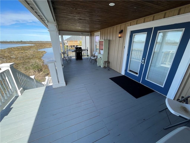 wooden deck featuring french doors and a water view