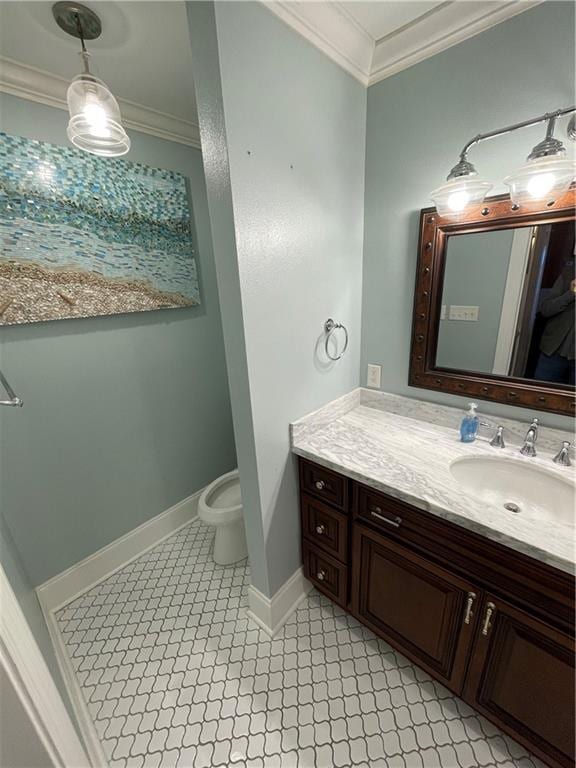 bathroom with vanity, crown molding, toilet, and baseboards