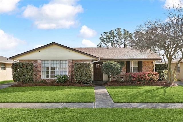 ranch-style house with a front lawn and brick siding