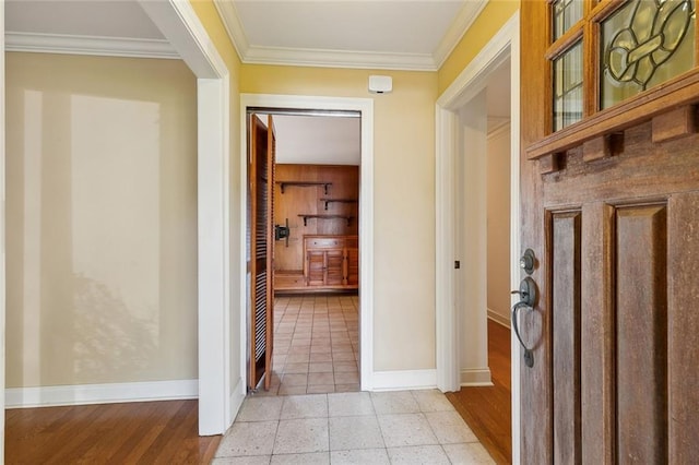 hall with light tile patterned floors, baseboards, and ornamental molding