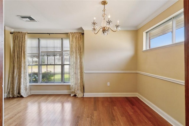 unfurnished dining area with visible vents, plenty of natural light, a notable chandelier, and wood finished floors