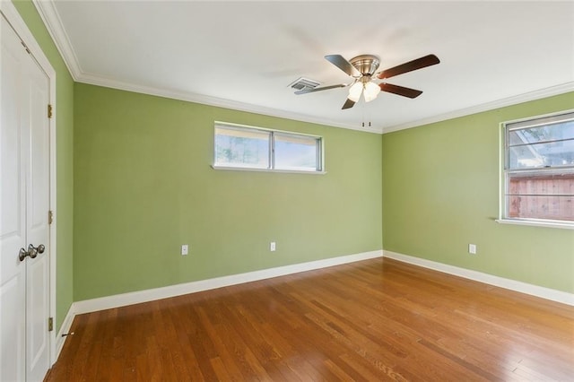 unfurnished bedroom with multiple windows, wood finished floors, visible vents, and baseboards