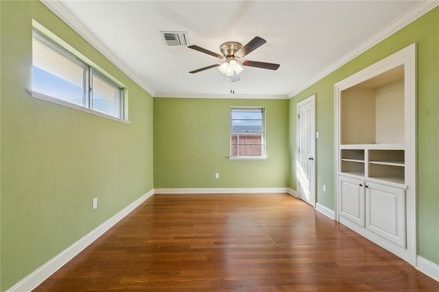 unfurnished bedroom with crown molding, baseboards, and wood finished floors