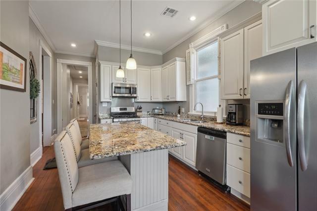 kitchen featuring ornamental molding, visible vents, appliances with stainless steel finishes, and a sink