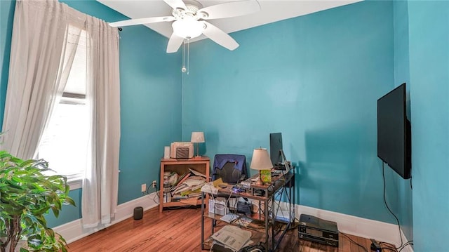 misc room with wood finished floors, baseboards, and ceiling fan