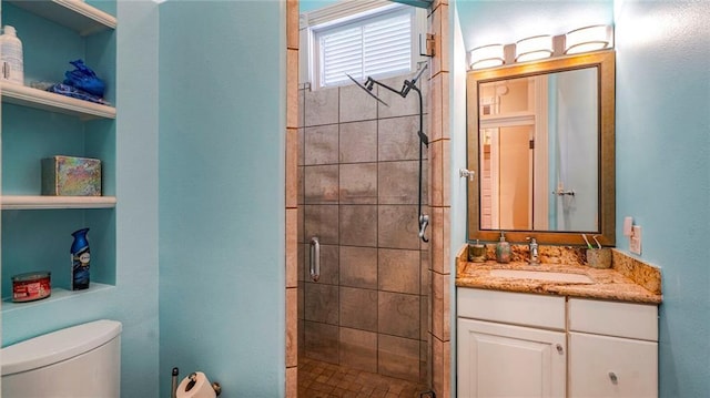 bathroom featuring vanity, toilet, and a stall shower