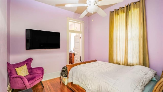 bedroom with wood finished floors, baseboards, and ceiling fan