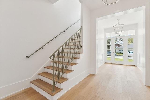 315 Sena Dr, Metairie, LA 70005 - stairs featuring baseboards, wood finished floors, and a chandelier