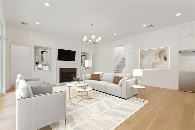 315 Sena Dr, Metairie, LA 70005 - living area with light wood-type flooring, an inviting chandelier, stairs, and visible vents