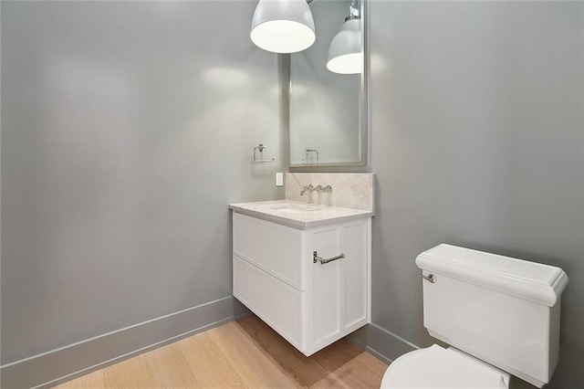 315 Sena Dr, Metairie, LA 70005 - half bathroom featuring toilet, wood finished floors, vanity, and baseboards