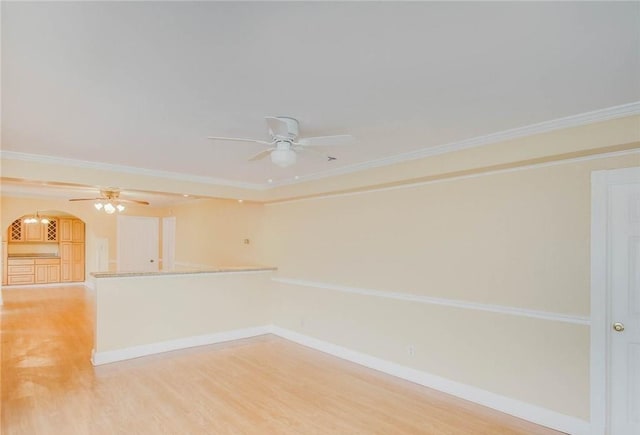 unfurnished room with crown molding, baseboards, and light wood-type flooring