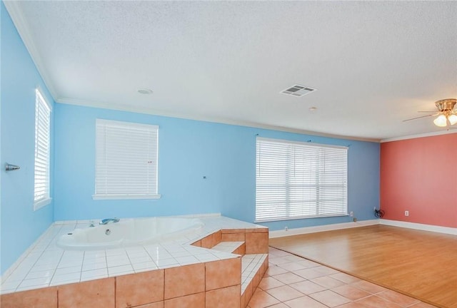 unfurnished room with ceiling fan, crown molding, visible vents, and a textured ceiling