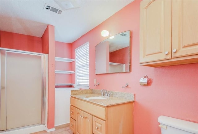 bathroom featuring vanity, visible vents, tile patterned flooring, a shower stall, and toilet