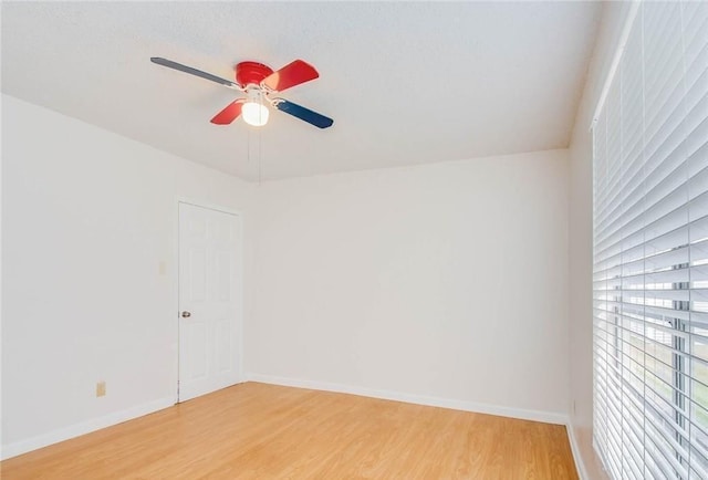 unfurnished room with a ceiling fan, light wood-type flooring, and baseboards