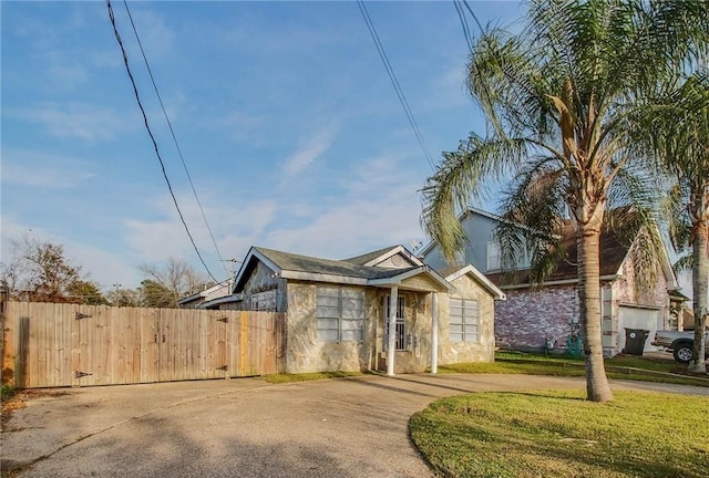 ranch-style house with a front yard, fence, and driveway