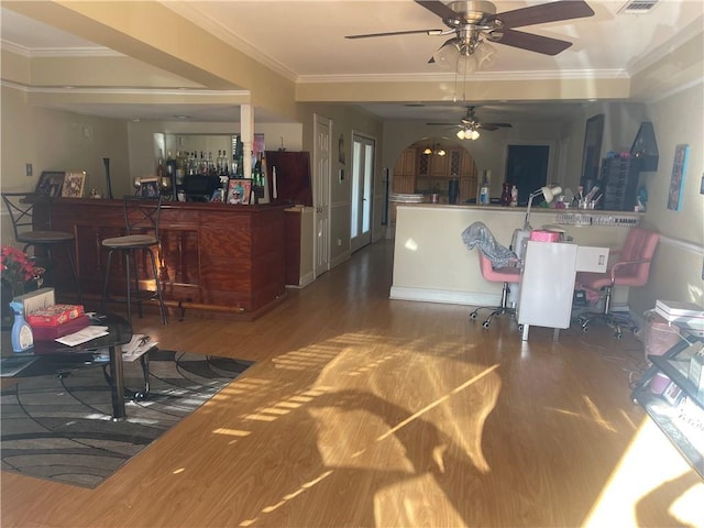 living room featuring a dry bar, ornamental molding, wood finished floors, and ceiling fan