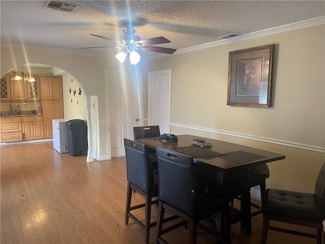 dining area with visible vents, light wood-style floors, and ornamental molding