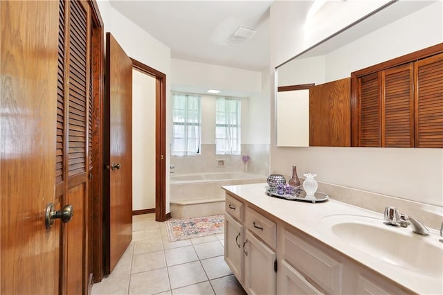 bathroom with tile patterned flooring, a bath, vanity, and a closet