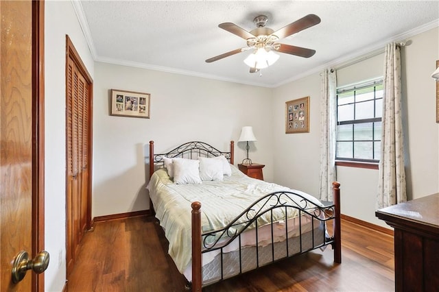 bedroom with a textured ceiling, crown molding, baseboards, and wood finished floors