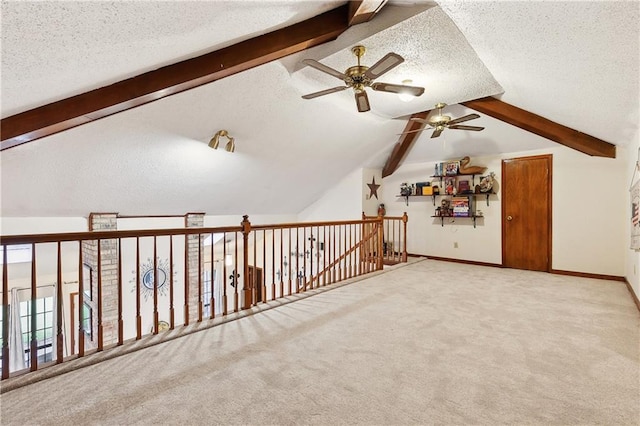 additional living space with vaulted ceiling with beams, baseboards, carpet, ceiling fan, and a textured ceiling