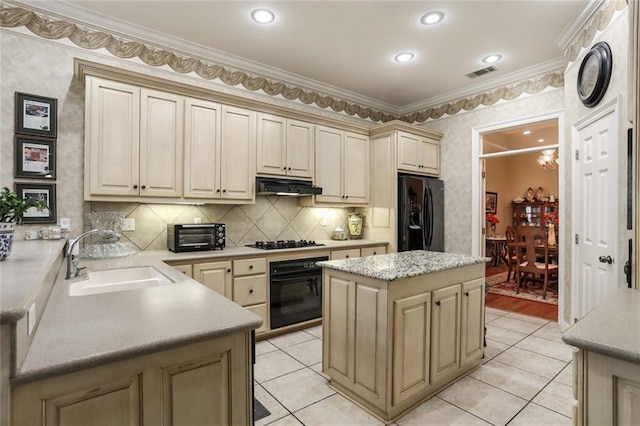 kitchen featuring crown molding, a sink, black appliances, under cabinet range hood, and visible vents