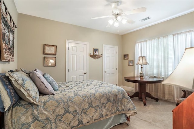 bedroom with light carpet, a ceiling fan, and visible vents