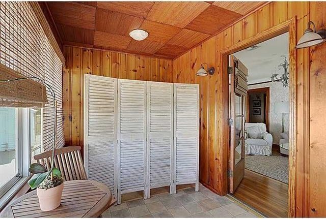 interior space with wood ceiling and wood walls