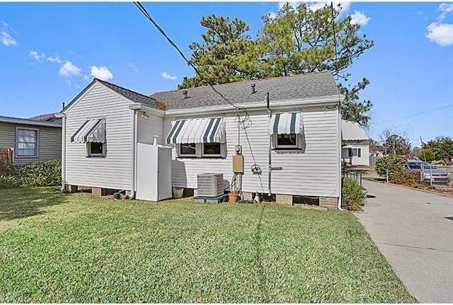 back of property with a yard and central AC unit