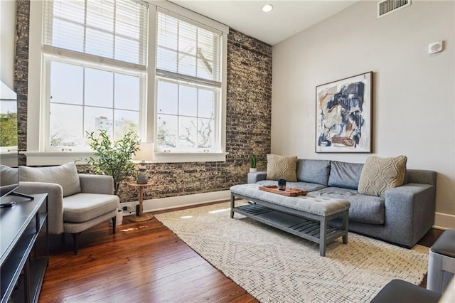 living area with dark wood finished floors, visible vents, recessed lighting, and baseboards