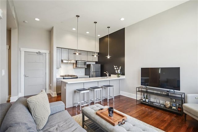 living room featuring dark wood finished floors, recessed lighting, and baseboards