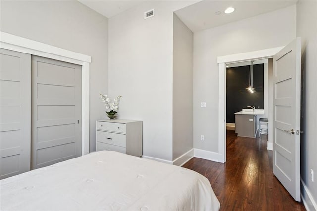 bedroom with recessed lighting, wood finished floors, visible vents, and baseboards