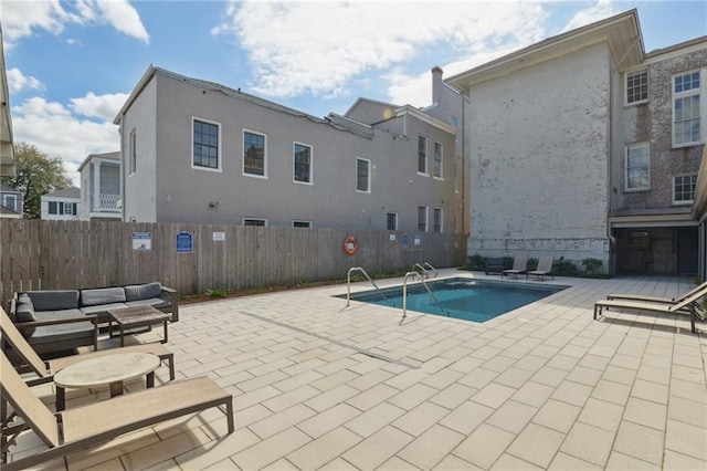 view of swimming pool featuring a patio area, an outdoor hangout area, and fence