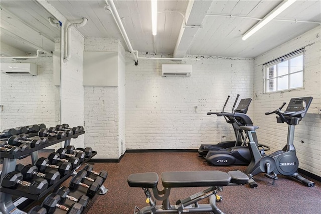 exercise room with an AC wall unit and brick wall