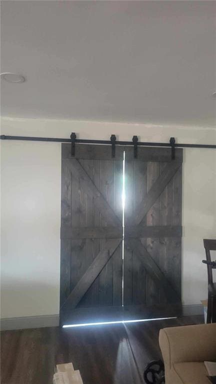 details featuring a barn door and wood finished floors