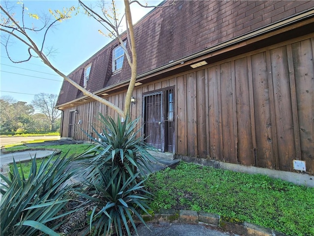 9 Whitney Ave Unit N, Harvey, LA 70058 - rear view of house with a shingled roof, board and batten siding, and mansard roof