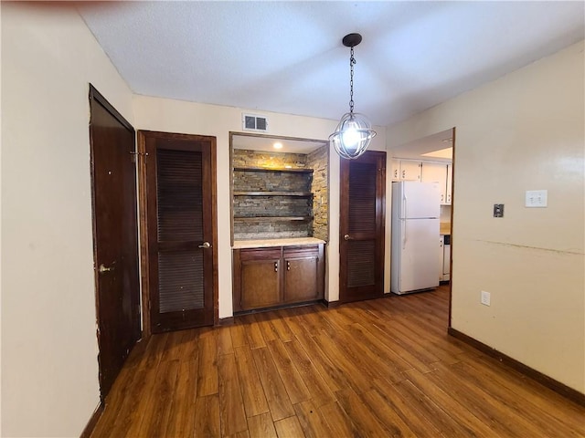 9 Whitney Ave Unit N, Harvey, LA 70058 - unfurnished dining area featuring dark wood-type flooring and baseboards