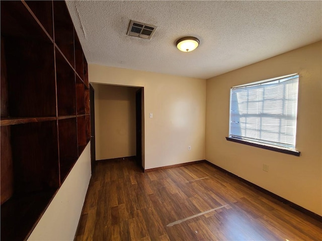 9 Whitney Ave Unit N, Harvey, LA 70058 - unfurnished room featuring dark wood-style flooring, baseboards, and a textured ceiling