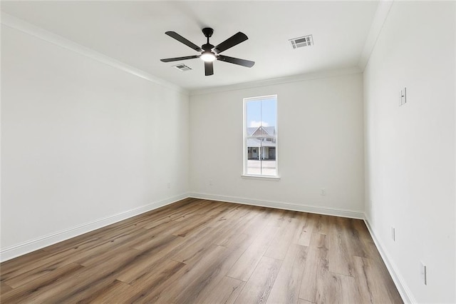 spare room with visible vents, crown molding, ceiling fan, and wood finished floors