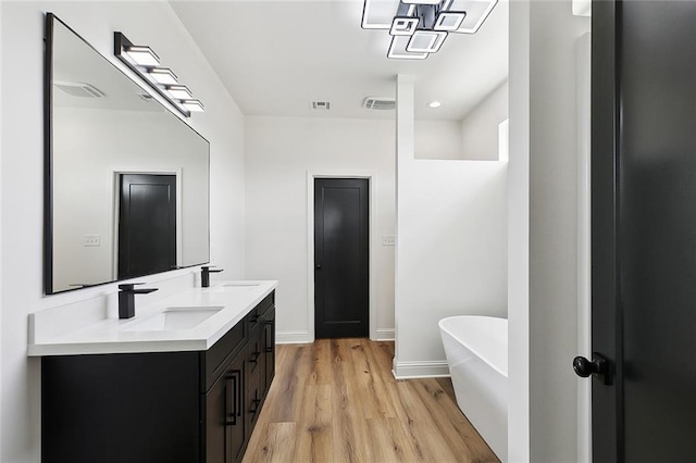 bathroom with a sink, visible vents, and a soaking tub