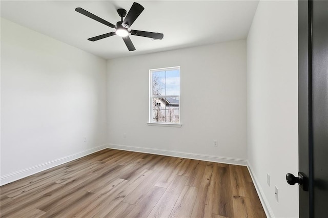 spare room featuring ceiling fan, baseboards, and wood finished floors