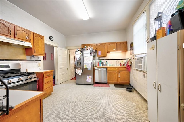 kitchen featuring under cabinet range hood, light countertops, cooling unit, appliances with stainless steel finishes, and a sink