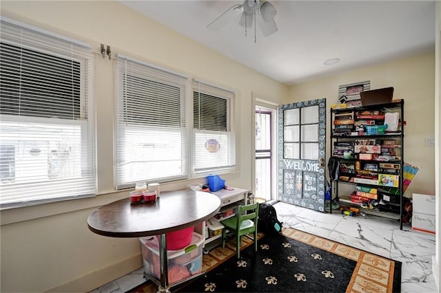 interior space featuring baseboards and a ceiling fan