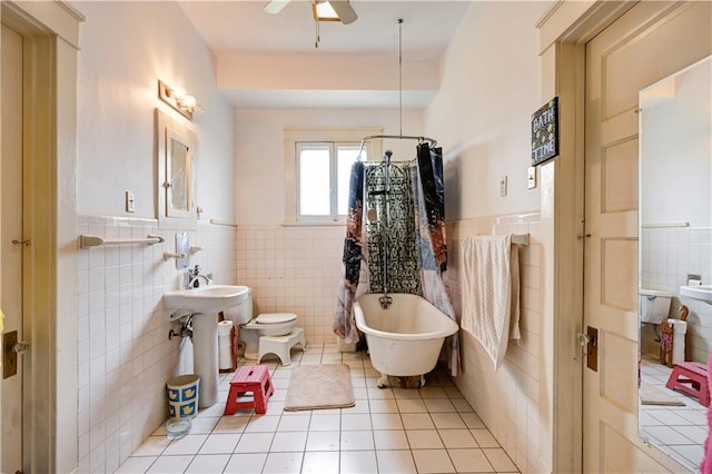 full bath with curtained shower, a freestanding bath, wainscoting, tile patterned floors, and a ceiling fan