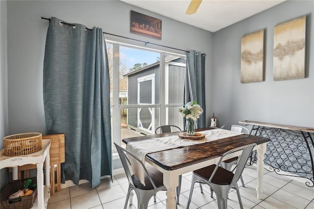 dining space with light tile patterned flooring and a ceiling fan