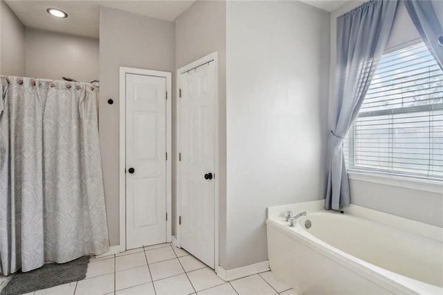 full bath with tile patterned flooring, a garden tub, baseboards, and a shower with shower curtain