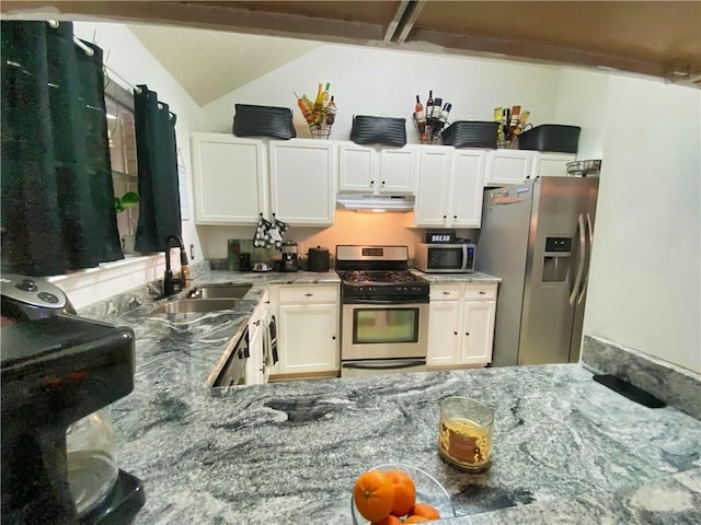 kitchen featuring under cabinet range hood, a sink, appliances with stainless steel finishes, white cabinets, and lofted ceiling