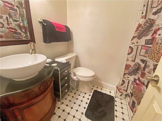 bathroom featuring vanity, tile patterned floors, toilet, and baseboards