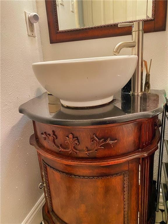 interior details with a sink, baseboards, and a textured wall