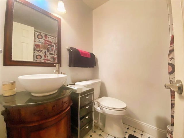 bathroom featuring tile patterned floors, toilet, vanity, and baseboards